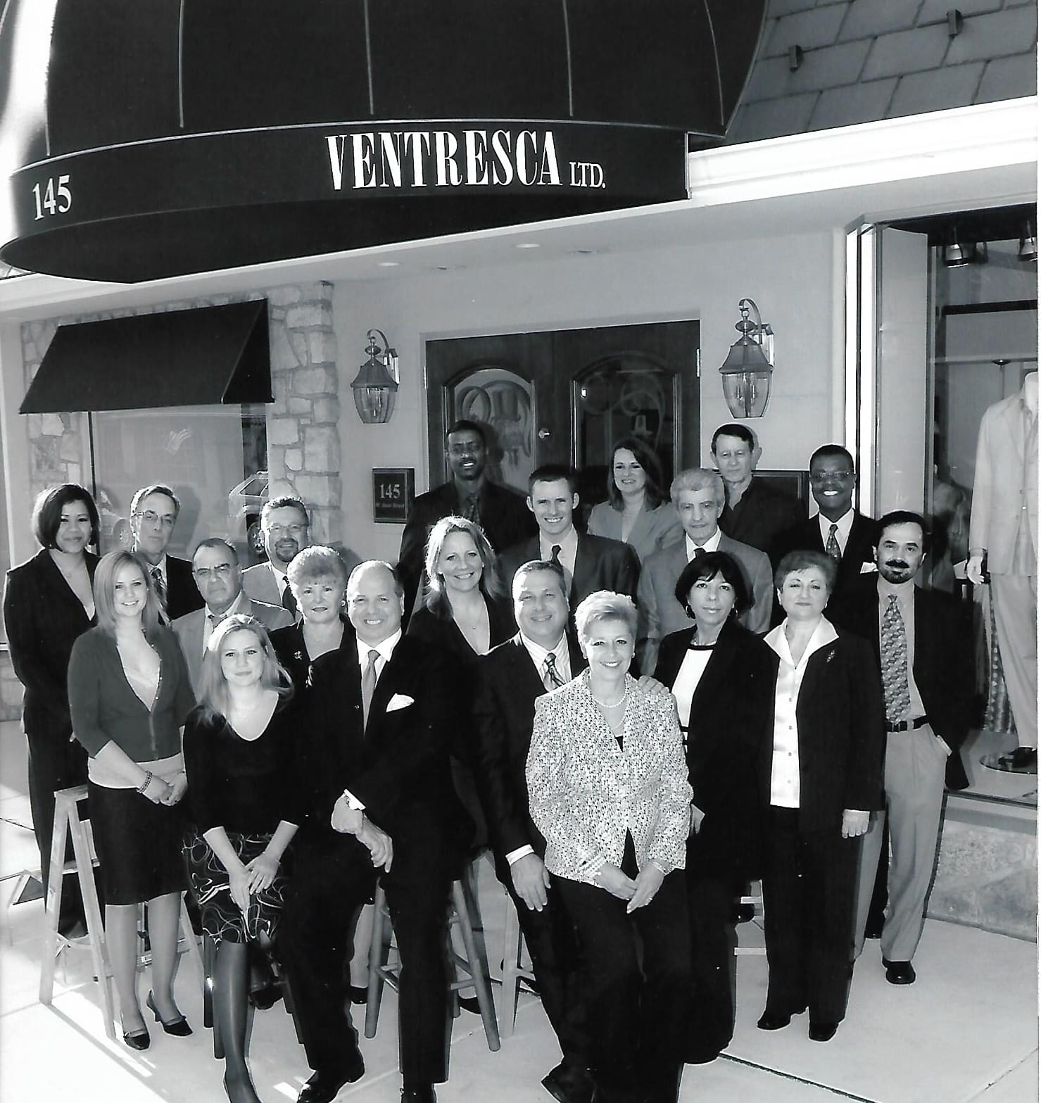 A black-and-white photo of the staff gathered outside the new Doylestown store, under an awning reading 145 Ventresca Ltd.
